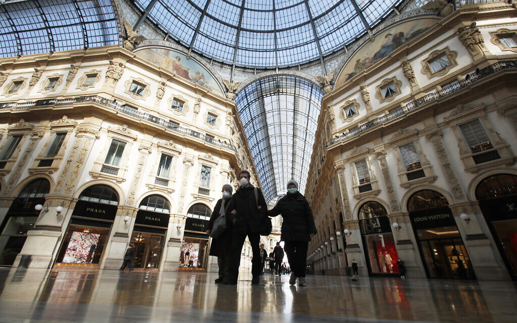 People wear masks as they walks inside Vittorio Emanuele II gallery, in downtown Milan, Italy, Sunday, March 8, 2020. (AP/Antonio Calanni)