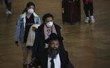 Passengers wear masks at Ben Gurion Airport near Tel Aviv, Israel, March 10, 2020 (AP Photo/Ariel Schalit)
