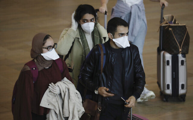 Passengers wearing masks to help protect against coronavirus arrive at Ben Gurion Airport near Tel Aviv, Tuesday, March 10, 2020. (AP Photo/Ariel Schalit) Passengers wearing masks to help protect against coronavirus arrive at Ben Gurion Airport near Tel Aviv, Tuesday, March 10, 2020. (AP Photo/Ariel Schalit)