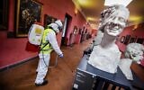 A worker sprays disinfectant as sanitization operations against Coronavirus are carried out in the museum hosted by the Maschio Angioino medieval castle, in Naples, Italy, March 10, 2020. (Alessandro Pone/LaPresse via AP)