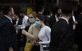 Illustrative: Jewish ultra-Orthodox girls wear face masks during celebrations of the Jewish festival of Purim in Bnei Brak, Israel, March 10, 2020 (AP Photo/Oded Balilty)