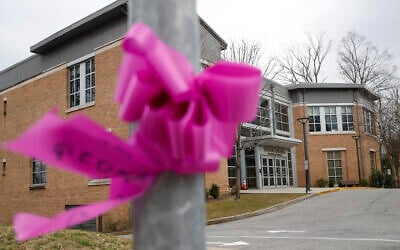 Pink ribbons, displayed for community support, are tied to polls and trees outside the Young Israel synagogue, Tuesday, March 10, 2020, in New York. State officials are shuttering several schools and houses of worship for two weeks in the New York City suburb and sending in the National Guard to help with what appears to be the nation's biggest cluster of coronavirus cases, Gov. Andrew Cuomo said Tuesday. (AP Photo/John Minchillo)