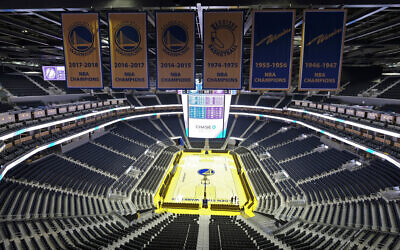In this Aug. 26, 2019, file photo, the Golden State Warriors championship banners hang above the seating and basketball court at the Chase Center in San Francisco (AP Photo/Eric Risberg, File)