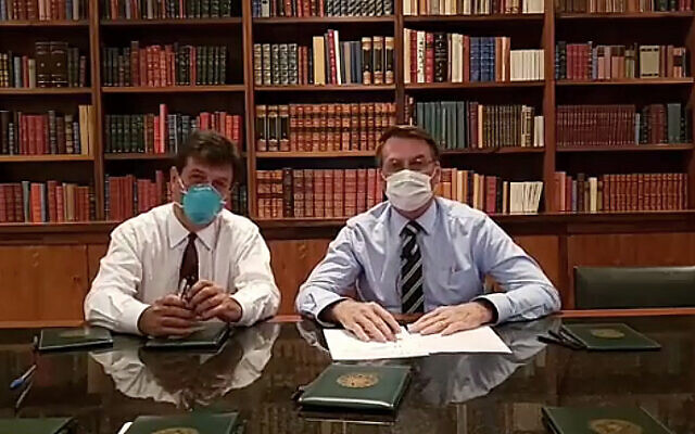 In this handout photo released by Brazil's Presidential Press Office, Brazilian Health Minister Luiz Henrique Mandetta, left, and President Jair Bolsonaro, wear masks as they speak about the new coronavirus during a Facebook Live transmission, in Brasilia, Brazil, Thursday, March 12, 2020.(Brazil's Presidential Press Office via AP) In this handout photo released by Brazil's Presidential Press Office, Brazilian Health Minister Luiz Henrique Mandetta, left, and President Jair Bolsonaro, wear masks as they speak about the new coronavirus during a Facebook Live transmission, in Brasilia, Brazil, Thursday, March 12, 2020.(Brazil's Presidential Press Office via AP)
