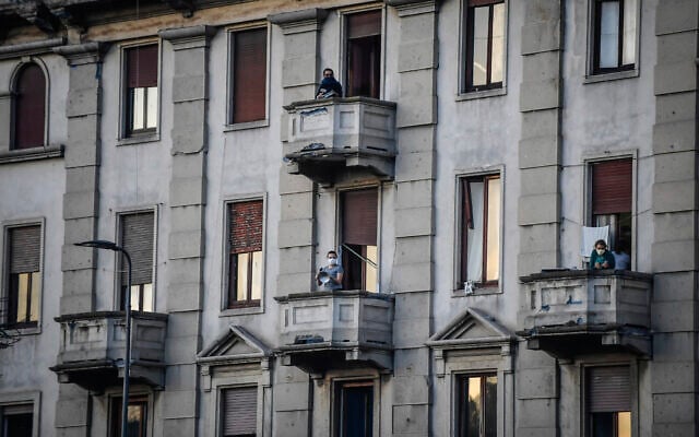 People lean out of their home's balconies to play and sing during a flash mob launched throughout Italy to bring people together and try to cope with the emergency of coronavirus, in Milan, Italy, March 13, 2020 (Claudio Furlan/LaPresse via AP) People lean out of their home's balconies to play and sing during a flash mob launched throughout Italy to bring people together and try to cope with the emergency of coronavirus, in Milan, Italy, March 13, 2020 (Claudio Furlan/LaPresse via AP)