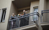 A man plays guitar on the balcony of his home during a flash mob launched throughout Italy to bring people together and try to cope with the emergency of coronavirus, in Milan, Italy,March 13, 2020 (AP Photo/Luca Bruno)