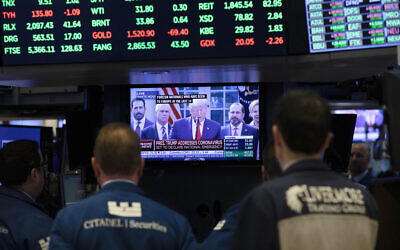 Traders listen at the New York Stock Exchange to US President Donald Trump's televised speech from the White House, March 13, 2020, in New York. (AP Photo/Mark Lennihan)