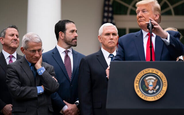 Dr. Anthony Fauci, director of the National Institute of Allergy and Infectious Diseases, listens as President Donald Trump speaks during a news conference on the coronavirus in the Rose Garden at the White House, Friday, March 13, 2020, in Washington. (AP Photo/Evan Vucci)