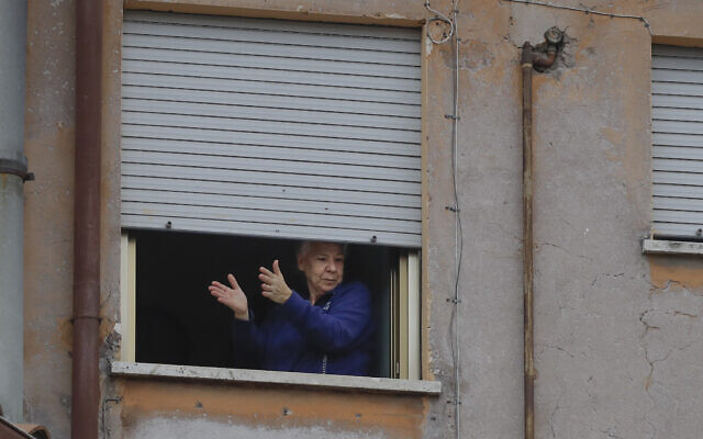A woman applauds from her window at the Garbatella neighborhood in Rome, March 14, 2020 (AP Photo/Alessandra Tarantino) A woman applauds from her window at the Garbatella neighborhood in Rome, March 14, 2020 (AP Photo/Alessandra Tarantino)