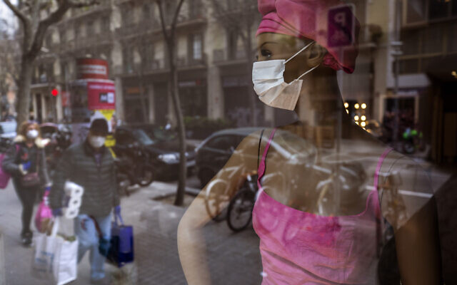 People wearing masks and carrying supplies walk past a mannequin wearing a mask in downtown Barcelona, Spain, March 14, 2020 (AP Photo/Emilio Morenatti) People wearing masks and carrying supplies walk past a mannequin wearing a mask in downtown Barcelona, Spain, March 14, 2020 (AP Photo/Emilio Morenatti)
