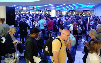 In this Saturday, March 15, 2020, photo, travelers wait in line to go through customs at O'Hare International Airport in Chicago.  (Michael Sadler via AP)
