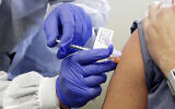 A man receives a shot in the first-stage safety study clinical trial of a potential vaccine for COVID-19, March 16, 2020, at the Kaiser Permanente Washington Health Research Institute in Seattle. (AP Photo/Ted S. Warren)
