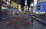 A woman walks through a lightly trafficked Times Square in New York, March 16, 2020. (AP/Seth Wenig)
