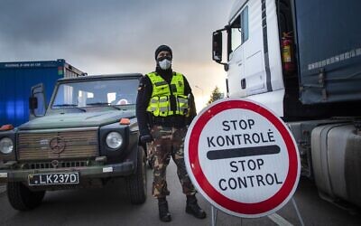 Illustrative:  A Lithuanian border guard stands next to trucks stuck in traffic jams for 60 kilometers (36 miles) on the Lithuanian border to enter Poland Tuesday, March 17, 2020. (AP Photo/Mindaugas Kulbis)