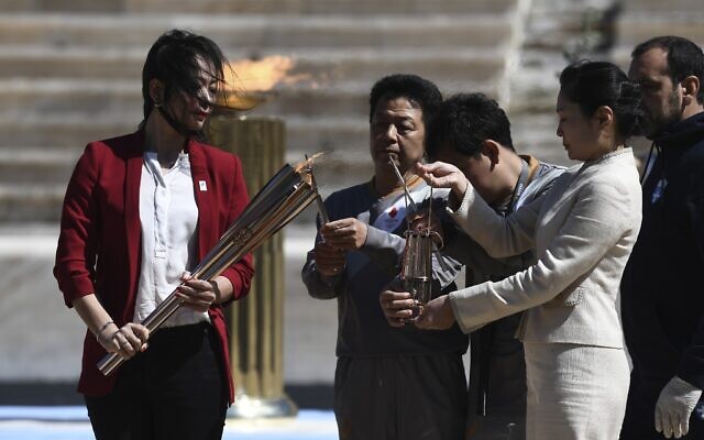 Former Japanese swimmer Imoto Naoko holds the Olympic torch during the Olympic flame handover ceremony for the 2020 Tokyo Summer Olympics, in Athens, March 19, 2020.(Aris Messinis/Pool via AP) Former Japanese swimmer Imoto Naoko holds the Olympic torch during the Olympic flame handover ceremony for the 2020 Tokyo Summer Olympics, in Athens, March 19, 2020.(Aris Messinis/Pool via AP)