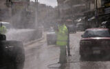 An employee of the Greater Amman Municipality sanitizes vehicles at one of their stations, amid concerns over the coronavirus pandemic, in Amman, Jordan, March 19, 2020. (AP Photo/Raad Adayleh)