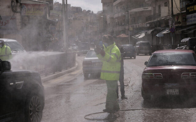 An employee of the Greater Amman Municipality sanitizes vehicles at one of their stations, amid concerns over the coronavirus pandemic, in Amman, Jordan, March 19, 2020. (AP Photo/Raad Adayleh) An employee of the Greater Amman Municipality sanitizes vehicles at one of their stations, amid concerns over the coronavirus pandemic, in Amman, Jordan, March 19, 2020. (AP Photo/Raad Adayleh)