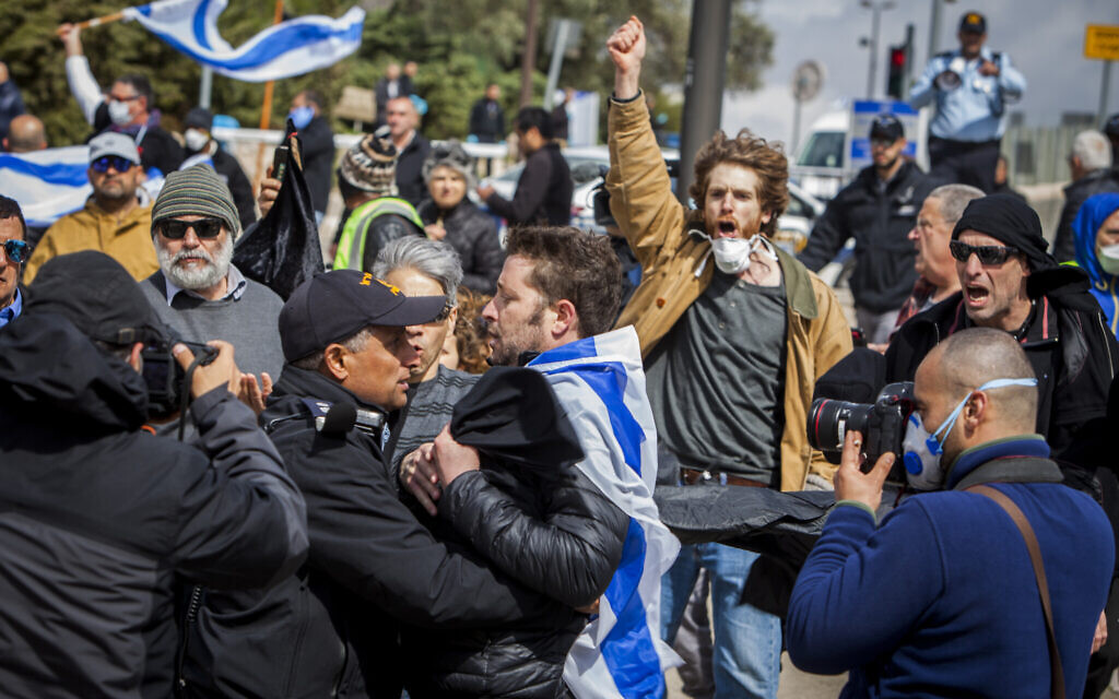 Israeli police officers scuffle with a man during a protest to "save democracy" outside the Knesset in Jerusalem, March 19, 2020. (AP Photo/Eyal Warshavsky) Israeli police officers scuffle with a man during a protest to "save democracy" outside the Knesset in Jerusalem, March 19, 2020. (AP Photo/Eyal Warshavsky)