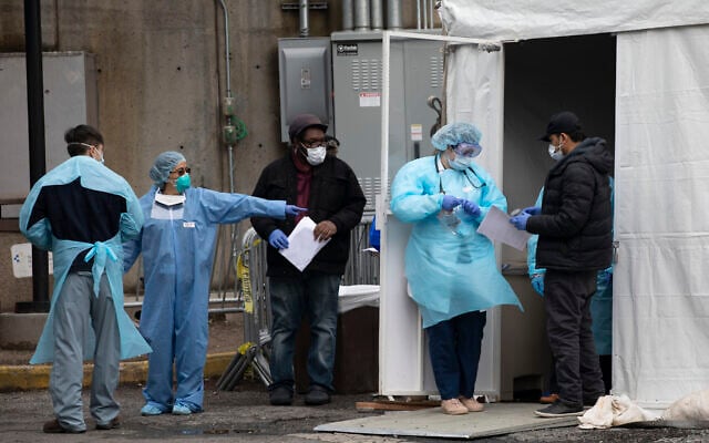 Hospital personnel assist people at a coronavirus screening tent outside the Brooklyn Hospital Center, March 19, 2020, in New York. (Mark Lennihan/AP) Hospital personnel assist people at a coronavirus screening tent outside the Brooklyn Hospital Center, March 19, 2020, in New York. (Mark Lennihan/AP)