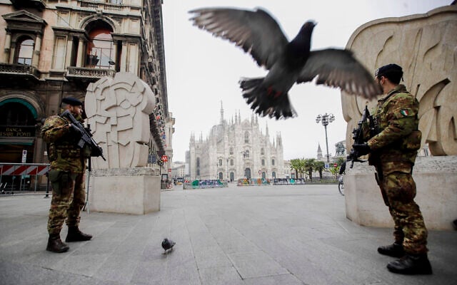 Italian soldiers patrol as the Duomo gothic cathedral is visible in background, in Milan, Friday, March 20, 2020. (AP Photo/Luca Bruno)
