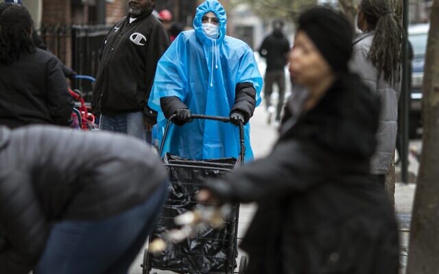 A woman dressed in a poncho, face mask and protective eyewear pushes her grocery cart in the Bedford-Stuyvesant neighborhood of Brooklyn, New York, on Friday, March 20, 2020. New York Gov. Andrew Cuomo is ordering all workers in non-essential businesses to stay home and banning gatherings statewide. Nonessential gatherings of individuals of any size or for any reason are canceled or postponed. (AP Photo/Wong Maye-E) A woman dressed in a poncho, face mask and protective eyewear pushes her grocery cart in the Bedford-Stuyvesant neighborhood of Brooklyn, New York, on Friday, March 20, 2020. New York Gov. Andrew Cuomo is ordering all workers in non-essential businesses to stay home and banning gatherings statewide. Nonessential gatherings of individuals of any size or for any reason are canceled or postponed. (AP Photo/Wong Maye-E)