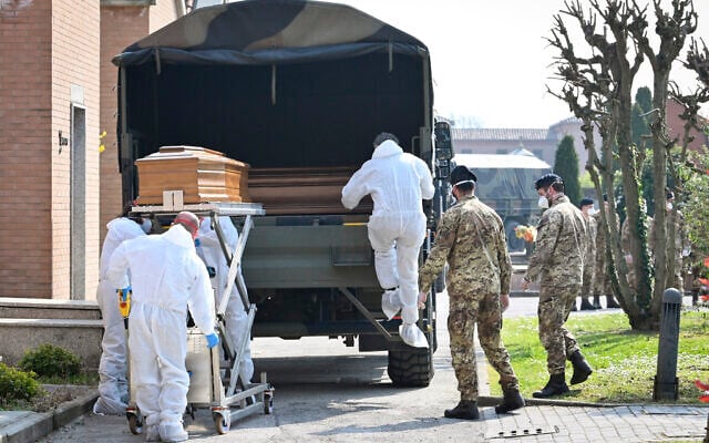 A convoy of Italian Army trucks is unloaded upon arrival from Bergamo carrying bodies of coronavirus victims to the cemetery of Ferrara, Italy, where they will be cremated, Saturday, March 21, 2020. The transfer was made necessary since Bergamo mortuary reached maximum capacity. For most people, the new coronavirus causes only mild or moderate symptoms. For some it can cause more severe illness, especially in older adults and people with existing health problems. (Massimo Paolone/LaPresse via AP) A convoy of Italian Army trucks is unloaded upon arrival from Bergamo carrying bodies of coronavirus victims to the cemetery of Ferrara, Italy, where they will be cremated, Saturday, March 21, 2020. The transfer was made necessary since Bergamo mortuary reached maximum capacity. For most people, the new coronavirus causes only mild or moderate symptoms. For some it can cause more severe illness, especially in older adults and people with existing health problems. (Massimo Paolone/LaPresse via AP)