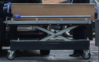 Undertakers carry a coffin of a person who died of COVID-19 at the La Almudena cemetery in Madrid, Spain, March 23, 2020. (Bernat Armangue/AP)
