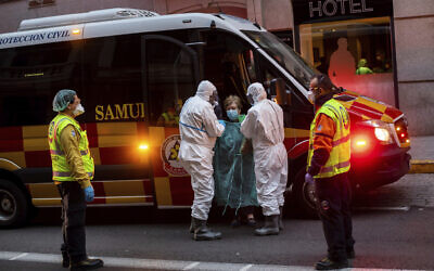 A patient is transferred to a hotel converted into a facility for coronavirus amid an outbreak in Madrid, Spain, March 24, 2020. (AP Photo/Bernat Armangue)