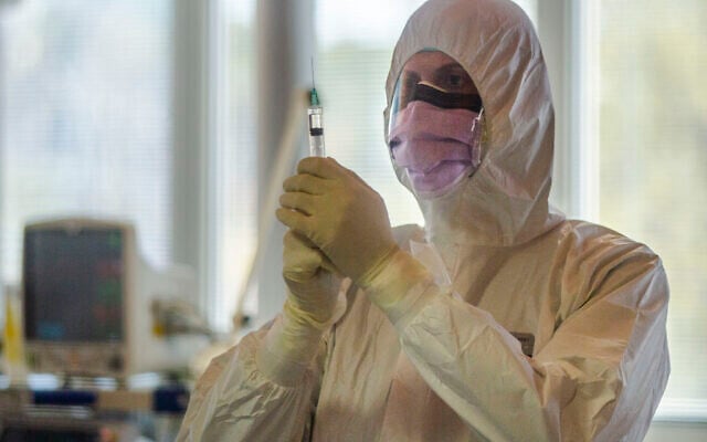 A medical staffer of the Intensive Care Unit of the Casalpalocco COVID-19 Clinic on the outskirts of Rome checks a syringe, March 25, 2020. (AP Photo/Domenico Stinellis) A medical staffer of the Intensive Care Unit of the Casalpalocco COVID-19 Clinic on the outskirts of Rome checks a syringe, March 25, 2020. (AP Photo/Domenico Stinellis)