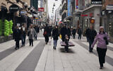 People walk along the main pedestrian shopping street in Stockholm, March 25, 2020. (AP Photo/David Keyton)