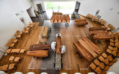 Coffins arriving from the Bergamo area, where the coronavirus infections caused many victims, being unloaded from a military truck that transported them in the cemetery of Cinisello Balsamo, near Milan in Northern Italy, March 27, 2020.  (Claudio Furlan/LaPresse via AP)