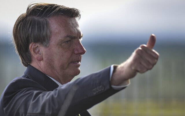 Brazil's President Jair Bolsonaro greets supporters and journalists as he arrives to give a news conference on the new coronavirus at Planalto presidential palace in Brasilia, Brazil, March 27, 2020. (AP Photo/Andre Borges) Brazil's President Jair Bolsonaro greets supporters and journalists as he arrives to give a news conference on the new coronavirus at Planalto presidential palace in Brasilia, Brazil, March 27, 2020. (AP Photo/Andre Borges)