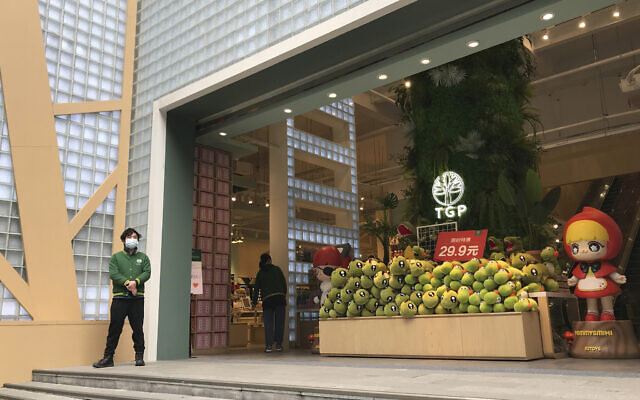 A store employee waits outside for customers at a re-opened retail street in Wuhan in central China's Hubei province on March 30, 2020. (AP Photo/Olivia Zhang) A store employee waits outside for customers at a re-opened retail street in Wuhan in central China's Hubei province on March 30, 2020. (AP Photo/Olivia Zhang)