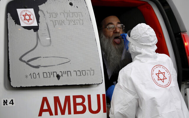 A medical worker wearing protective gear takes a swab from an ultra-Orthodox Jewish man for a coronavirus test in Bnei Brak, March 31, 2020. (AP Photo/Ariel Schalit) A medical worker wearing protective gear takes a swab from an ultra-Orthodox Jewish man for a coronavirus test in Bnei Brak, March 31, 2020. (AP Photo/Ariel Schalit)