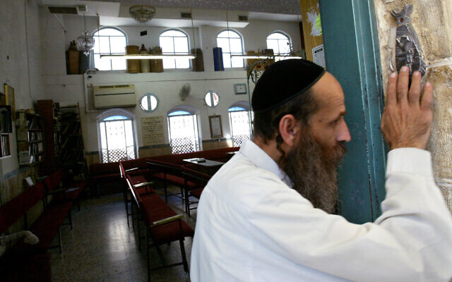 Illustrative: An ultra-Orthodox Jewish man kisses the mezuzah as he exits a synagogue in Jerusalem, August 5 2008. (Olivier Fitoussi /FLASH90) Illustrative: An ultra-Orthodox Jewish man kisses the mezuzah as he exits a synagogue in Jerusalem, August 5 2008. (Olivier Fitoussi /FLASH90)