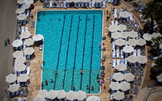 Tourists swim in a hotel pool in Tel Aviv,  on a warm summer day on July 04, 2017. (Miriam Alster/FLASH90)