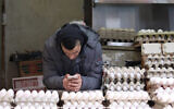 Illustrative: A salesman on his phone while selling eggs at an eggs tand in Jerusalem's Machane Yehuda Market, January 27, 2018.