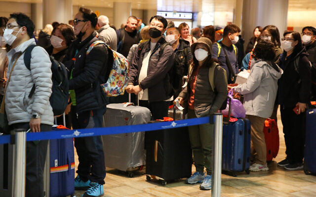 Illustrative: South Korean tourists wearing face masks for protection from the coronavirus wait for their flight at Ben Gurion International Airport on February 24, 2020. (Flash90) Illustrative: South Korean tourists wearing face masks for protection from the coronavirus wait for their flight at Ben Gurion International Airport on February 24, 2020. (Flash90)