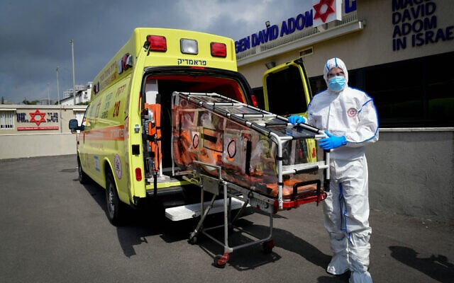 A Magen David Adom ambulance service worker wears protective clothing as a preventive measure against the coronavirus seen outside the special emergency call center in Kiryat Ono on February 26, 2020. (Flash90) A Magen David Adom ambulance service worker wears protective clothing as a preventive measure against the coronavirus seen outside the special emergency call center in Kiryat Ono on February 26, 2020. (Flash90)