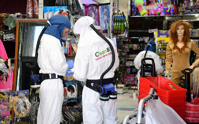 Workers disinfect a shop in Or Yehuda, after a man who works at the shop and returned from Italy tested positive for coronavirus, February 28, 2020. (Flash90 ) Workers disinfect a shop in Or Yehuda, after a man who works at the shop and returned from Italy tested positive for coronavirus, February 28, 2020. (Flash90 )