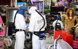 Workers disinfect a shop in Or Yehuda, after a man who works at the shop and returned from Italy tested positive for coronavirus, February 28, 2020. (Flash90)