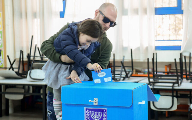 A voter and his daughter cast a ballot at a voting station in Tel Aviv, March 2, 2020 (Flash90) A voter and his daughter cast a ballot at a voting station in Tel Aviv, March 2, 2020 (Flash90)