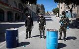 Palestinian security forces wearing face masks block the entrance to the West Bank city of Bethlehem, March 8, 2020. (Wisam Hashlamoun/Flash90)