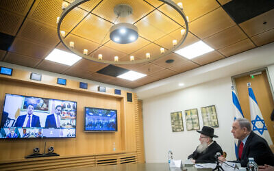 Prime Minister Benjamin Netanyahu, right, and Health Minister Yaakov Litzman hold a video conference with European leaders at the Foreign Ministry in Jerusalem, on March 9, 2020. (Yonatan Sindel/Flash90)