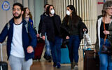 Illustrative: People wearing face masks at the Ben Gurion International Airport on March 10, 2020. (Avshalom Sassoni/ Flash90)
