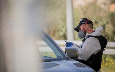 Israeli border police wear protective gear and masks at the Ein Yael Checkpoint, near the Jerusalem Biblical Zoo, March 11, 2020. (Yonatan Sindel/Flash90)
