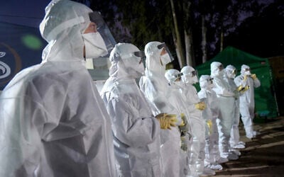 Workers inside a building at Tel HaShomer Hospital which was converted to receive Israelis who were under quarantine on the cruise ship Diamond Princess in Japan due to the spread of the coronavirus, February 20, 2020. (Avshalom Sassoni/Flash90)