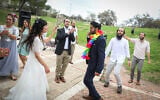 Hananel Even Hen and Shiran Habush celebrate during thier wedding at a public park in Efrat, in Gush Etzion, March 15, 2020, after their wedding was canceled due to new regulations following the spread of the coronavirus (Gershon Elinson/Flash90)