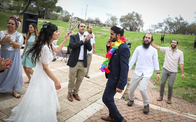 Hananel Even Hen and Shiran Habush celebrate during thier wedding at a public park in Efrat, in Gush Etzion, March 15, 2020, after their wedding was canceled due to new regulations following the spread of the coronavirus (Gershon Elinson/Flash90) Hananel Even Hen and Shiran Habush celebrate during thier wedding at a public park in Efrat, in Gush Etzion, March 15, 2020, after their wedding was canceled due to new regulations following the spread of the coronavirus (Gershon Elinson/Flash90)