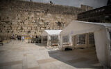 People pray in enclosed areas allowing prayers of 10 people in a time, at the Western Wall, in the Old City of Jerusalem, March 15, 2020. (Yonatan Sindel/Flash90)
